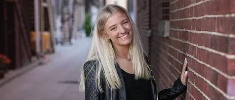 A student posing for a picture outside.